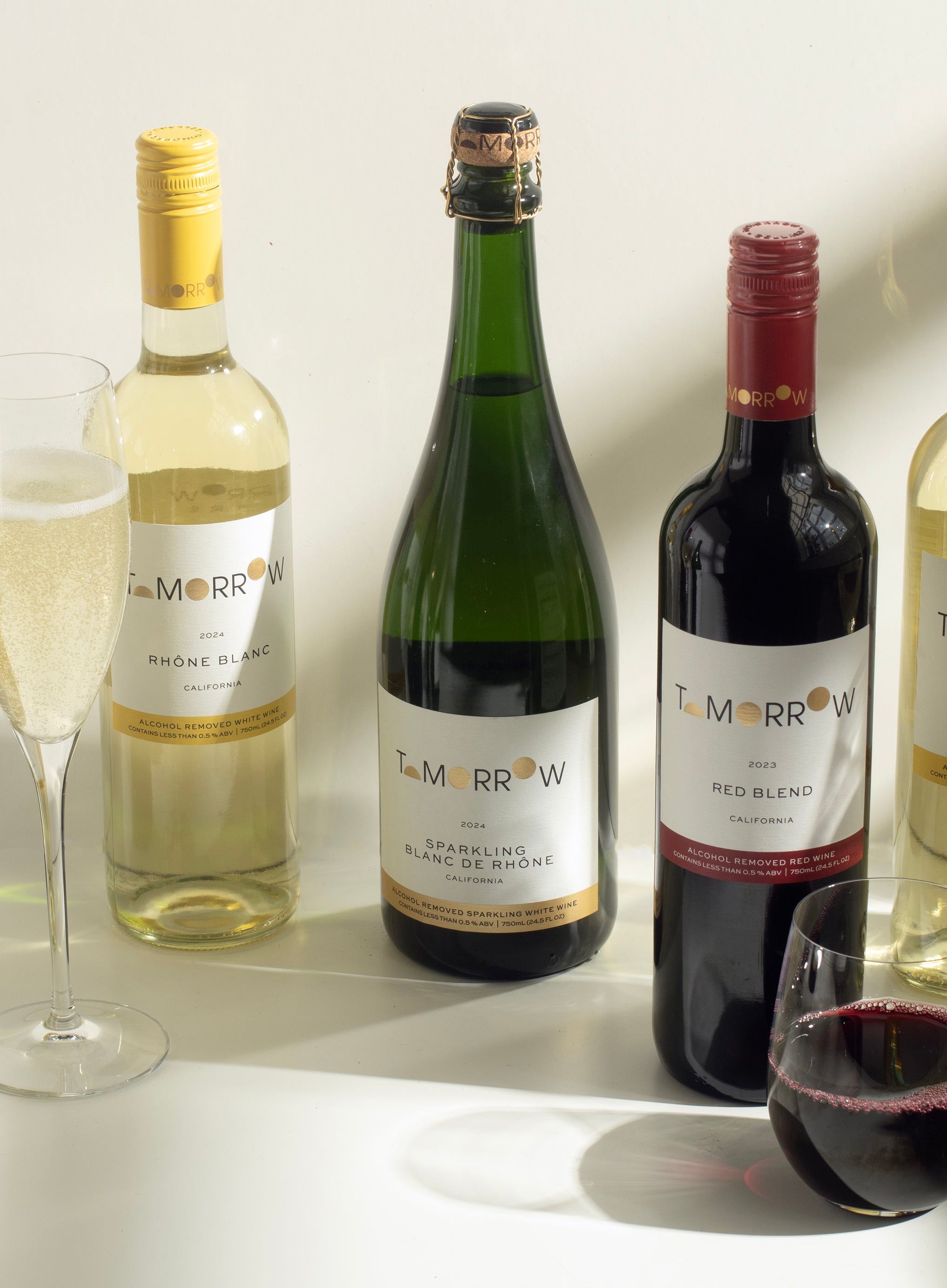 Wine glasses with non-alcoholic wine bottles showing 0.5% ABV label