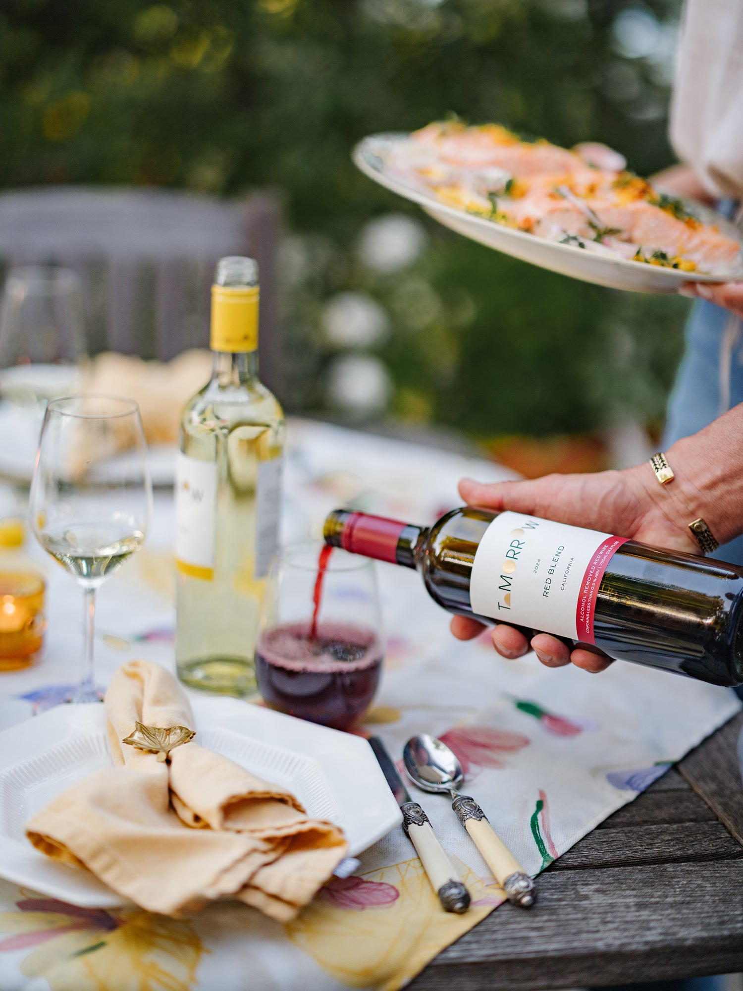 Non-alcoholic red wine being poured at a summer dinner party.